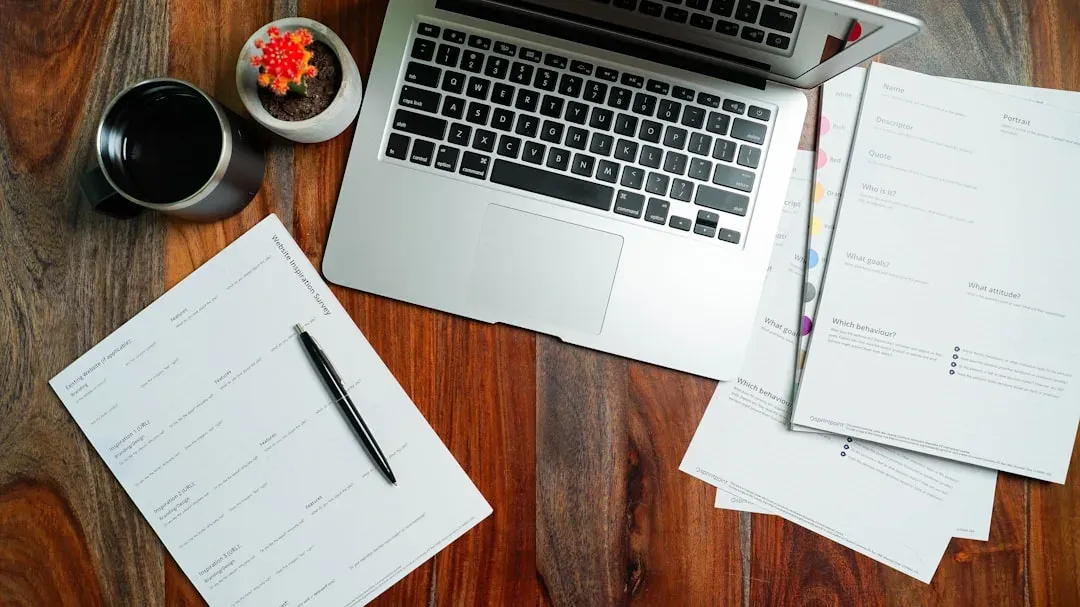 digital nomad working at a desk with laptop and papers